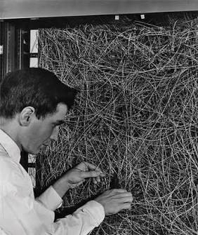 Frank Rosenblatt hand-wiring the Mark I Perceptron, a panel of tangled wires, in the late 1950s.